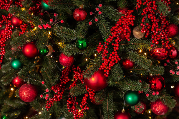 schöner Weihnachtsbaum mit leuchtenden roten und grünen Kugeln - Foto, Bild