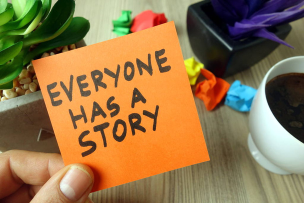 Lema Todo el mundo tiene una historia escrita a mano en nota adhesiva
 - Foto, imagen