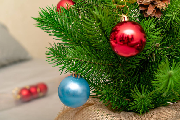 Nahaufnahme von bunten glänzenden festlichen Christbaumkugeln, die am Weihnachtsbaum hängen  - Foto, Bild