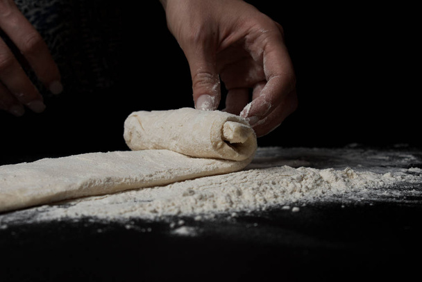 close-up partial view of woman preparing fresh homemade pastry on black background  - Foto, Imagem