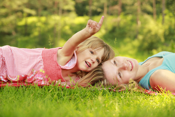 Мама играет со своей маленькой дочкой на траве
 - Фото, изображение