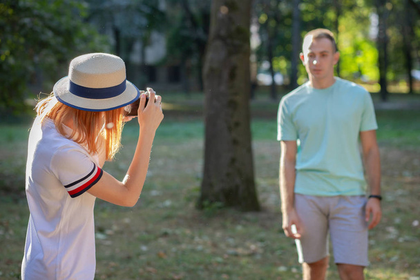 Young teenage couple taking pictures of one another outdoors in  - 写真・画像