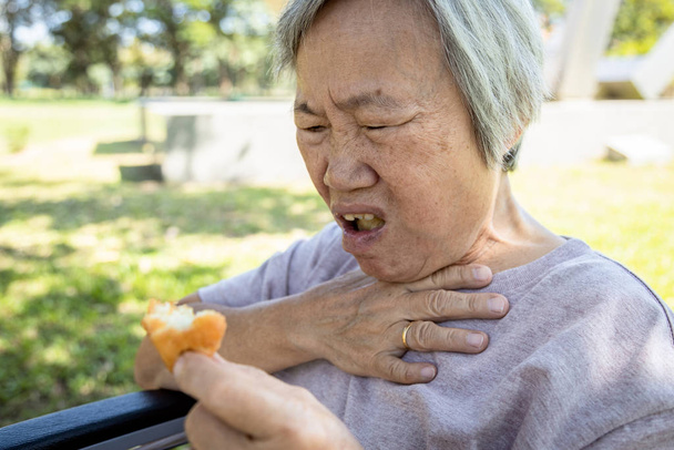 Les femmes âgées d'origine asiatique souffrent d'étouffement et de toux, d'engorgement des aliments, d'étouffement des personnes âgées pendant qu'elles mangent, d'engorgement de la gorge et d'asphyxie, de problèmes de santé, d'asphyxie et de suffocation., - Photo, image