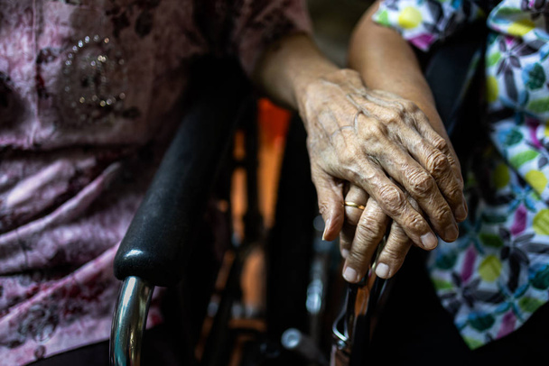 Ασιάτες ηλικιωμένοι και παλιοί φίλοι σε αναπηρική καρέκλα, κρατιούνται χέρι χέρι για να ενθαρρύνουν ο ένας τον άλλον σε στιγμές αποθάρρυνσης και απελπισίας, φροντίδας ηλικιωμένων, υποστήριξης, συμπόνιας και κατανόησης, φιλίας, αληθινής φιλίας  - Φωτογραφία, εικόνα