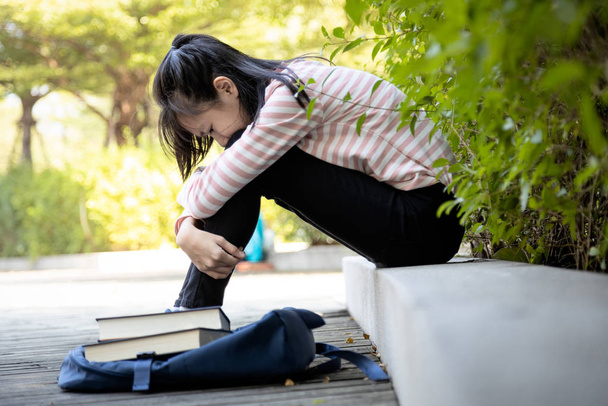 Depressed asijské dítě dívka student neuspěl důležitý test, žena student sedět objímat kolena až k hrudi a pláč sám, smutný školačka pocit stresu, zklamaný s její zkouškou na základní škole   - Fotografie, Obrázek