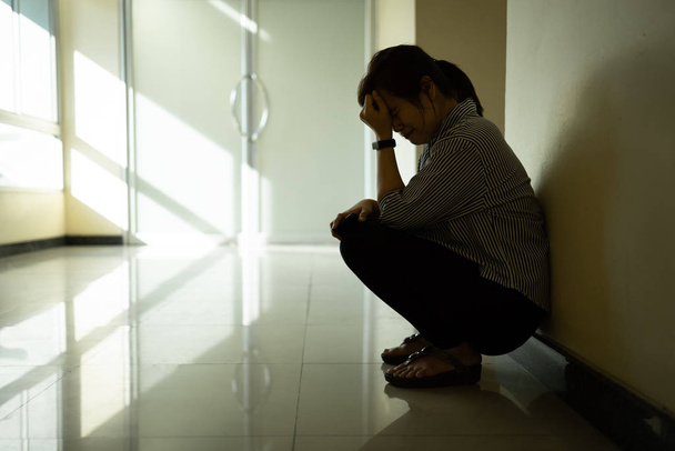 Aasialainen nainen istuu yksin pimeydessä, kärsii masennuksesta ja ahdistuksesta surullinen, itkeä, pettynyt, aikuinen naispuolinen ihminen huoli stressiä ajatella elämää, perheväkivallan käsite
   - Valokuva, kuva