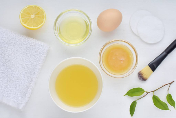 Mascarilla facial casera para la piel del acné, ingredientes naturales, miel, clara de huevo, limón, puesta plana sobre fondo blanco
. - Foto, imagen
