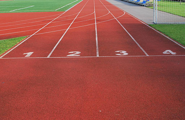 Red running track at the stadium. Running track start. - Photo, Image