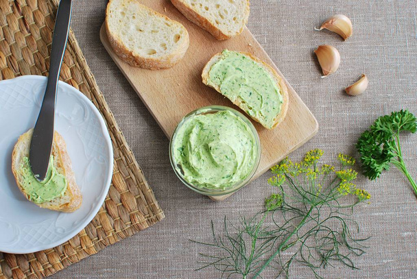 Butter with herbs and garlic, slices bread, dill and parsley. - Foto, afbeelding