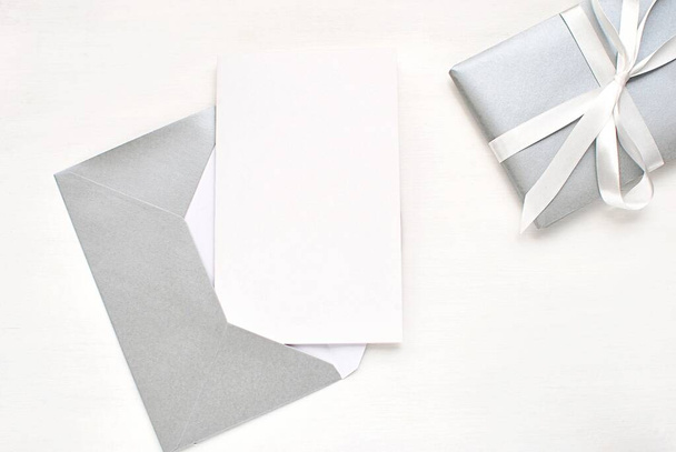 Modern flat lay with blank card and silver envelope, Christmas, New Years, wedding greeting card, invitation mock up. - Photo, Image