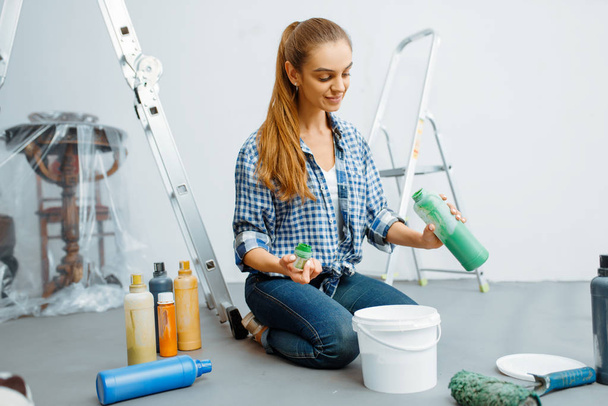 Kobieta malarka domowa miesza farby przed malowaniem. Naprawa domu, szczęśliwa kobieta robi remont mieszkania - Zdjęcie, obraz