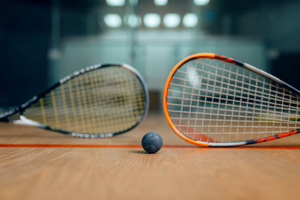 Két squash ütő és labda a pályán, senki, játék koncepció. Aktív sport hobbi, fitness edzés az egészséges életmódért - Fotó, kép
