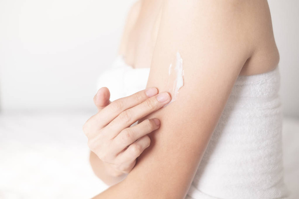 Donna che applica crema per le braccia, lozione, concetto di igiene della pelle cura del corpo - Foto, immagini