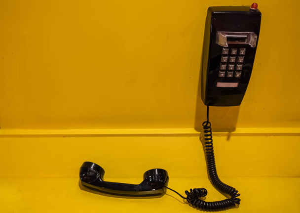 display del telefono nero in stile vintage su parete gialla
 - Foto, immagini