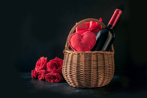 Valentines day gift hamper, bouquet of red roses, bottle of sparkling wine on black. - Photo, Image