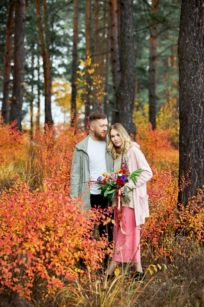 Couple in love walks through autumn forest. Hugs and kisses of m - Φωτογραφία, εικόνα