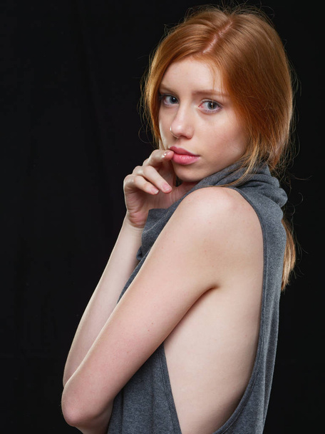 fiatal lány hosszú vörös haj egy fekete háttér - Fotó, kép