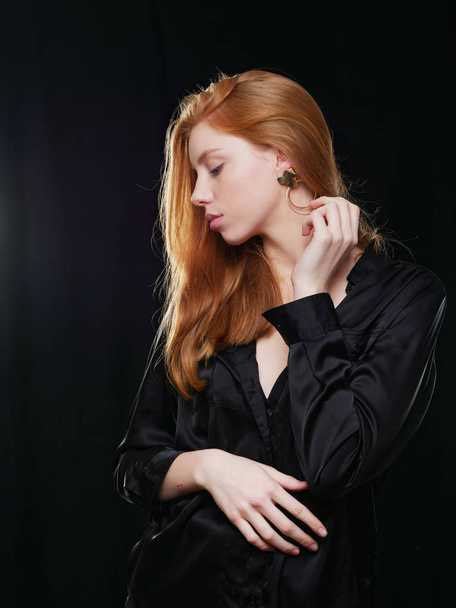 young girl with long red hair on a black background - Foto, Bild
