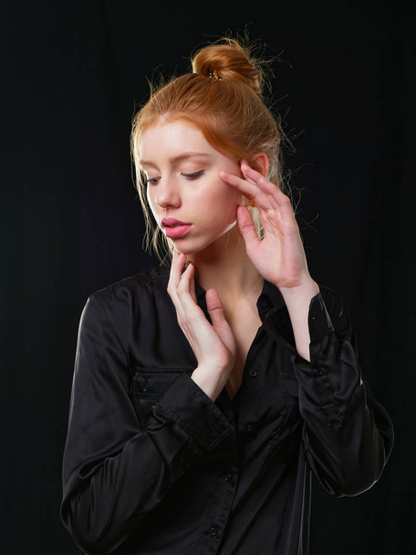 mladá dívka s dlouhými zrzavými vlasy na černém pozadí - Fotografie, Obrázek