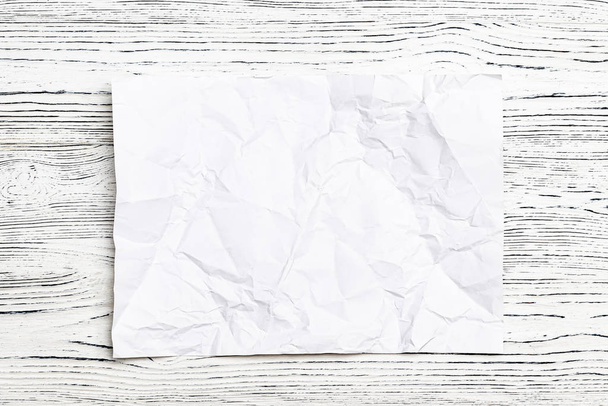 Crumpled white paper on a wooden table. - Photo, Image