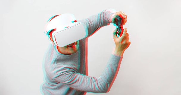 仮想現実ヘッドセットを持つ男がゲームをプレイしています。グリッチ効果のある画像. - 写真・画像