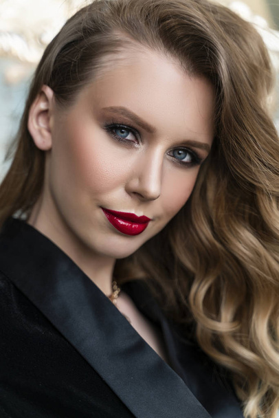 Portrait of a beautiful blonde girl with red lips and evening ma - 写真・画像