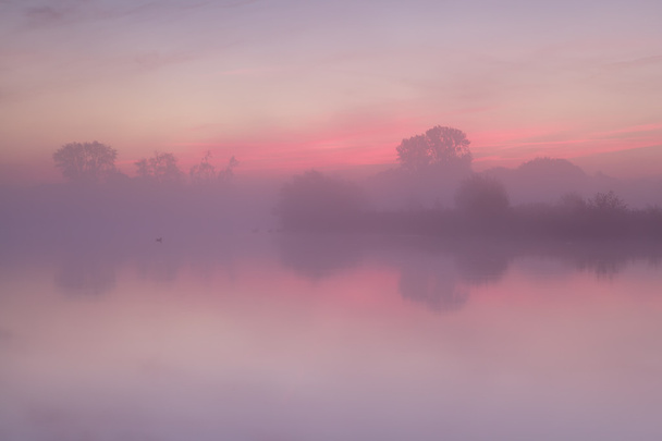 lever de soleil brumeux rouge sur un lac calme
 - Photo, image