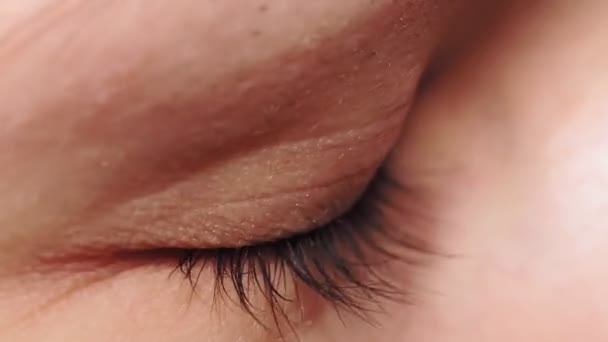 Macro close-up oog knippert. Jonge vrouw opent en sluit haar mooie oog. - Video