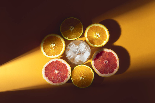 Цитрусові фрукти та склянка льоду на сонячному світлі. Виготовлення коктейлю
 - Фото, зображення