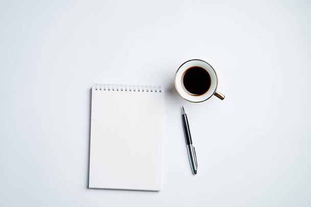 white office Desk top view with Notepad, pen and coffee Cup, minimalistic design,top view,copy space,flat lay - Foto, Imagen