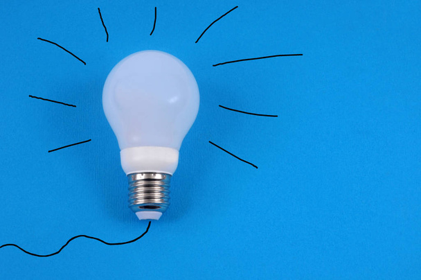 Idea concept with a screw light bulb close-up on a blue background - Photo, Image