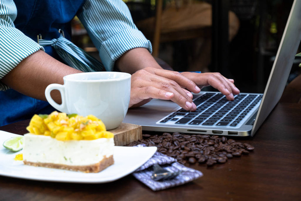 eine Frau, die mit dem Laptop in einem Café arbeitet und Kaffee trinkt - Foto, Bild