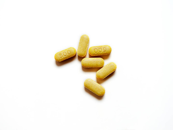 Comprimidos amarillos caducados medicamento de vitamina C sobre fondo blanco. Píldoras peligrosas para usar
. - Foto, imagen