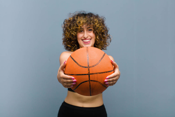 young pretty sports woman wearing fitness clothes with a basket ball - Foto, afbeelding