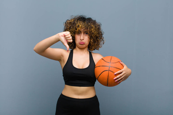 young pretty sports woman wearing fitness clothes with a basket ball - Фото, зображення