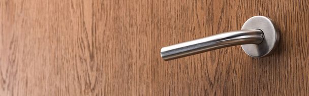 деревянная дверь гостиничного номера с металлической ручкой, панорамный снимок
 - Фото, изображение