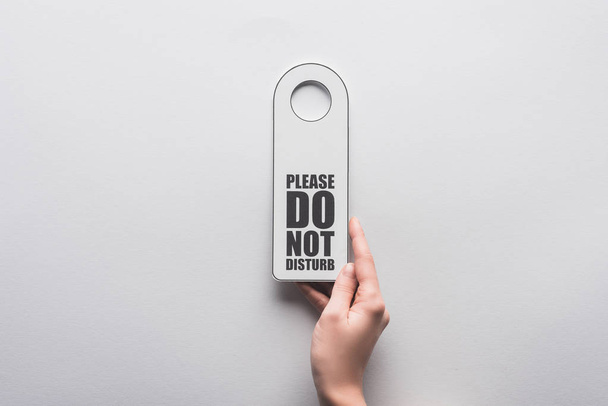 cropped view of woman holding please do no disturb sign on white background - Photo, Image