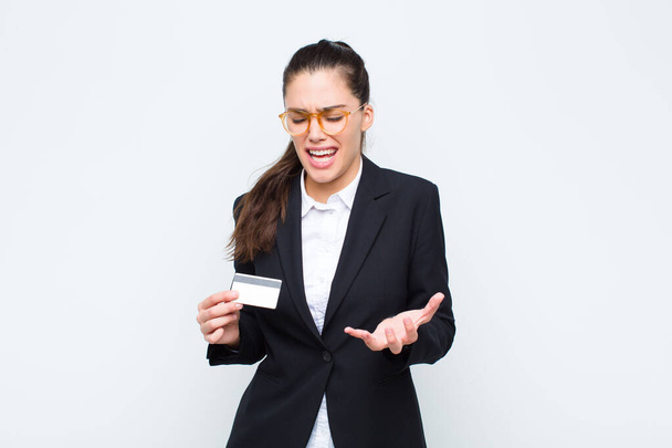 young businesswoman looking angry, annoyed and frustrated screaming or whats wrong with you with banknotes with bills - Foto, imagen