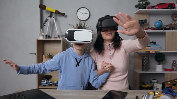 Slow motion of cheerful happy pleasant mother and son which wearing virtual reality headset having fun together at home - Video