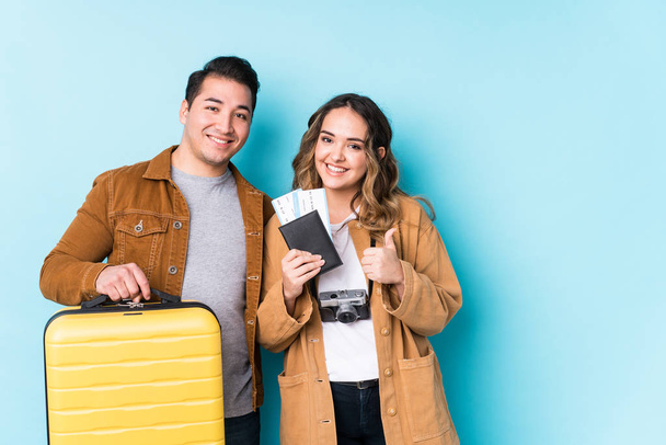 Young couple ready for a travel isolated smiling and raising thumb up - Photo, image
