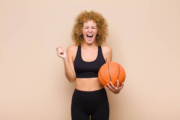 young afro woman looking extremely happy and surprised, celebrating success, shouting and jumping sport concept - Zdjęcie, obraz