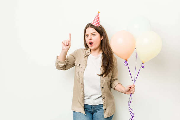 Νέοι συν μέγεθος καμπυλωτό γυναίκα γιορτάζει μια γενέθλια έχοντας μια ιδέα, έμπνευση έννοια. - Φωτογραφία, εικόνα