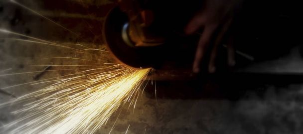 Sparks flying while machine griding and finishing metal.Selective focus. - Photo, Image