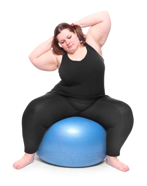 Tiro de una mujer joven con sobrepeso feliz con bola azul sobre un fondo blanco
. - Foto, imagen