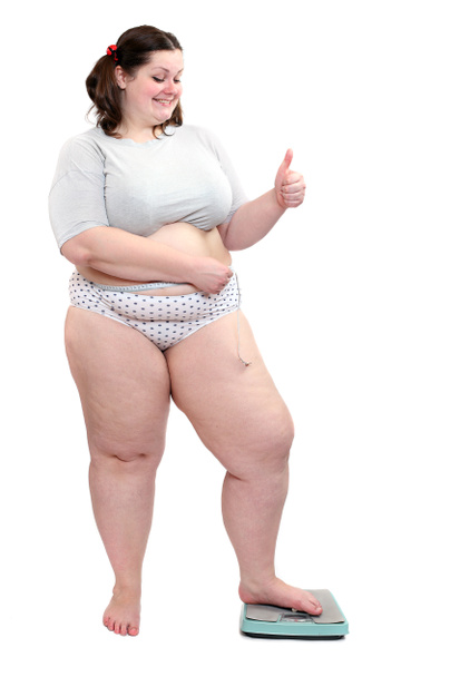 šťastný obézní žena měřit její břišní pás metr stick na vážicí zařízení. - Fotografie, Obrázek