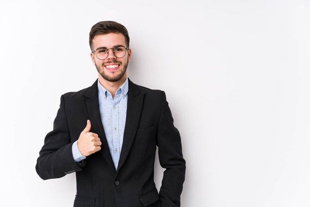 Jovem homem de negócios caucasiano posando em um fundo branco isolado Jovem homem de negócios caucasiano sorrindo e levantando o polegar
 - Foto, Imagem