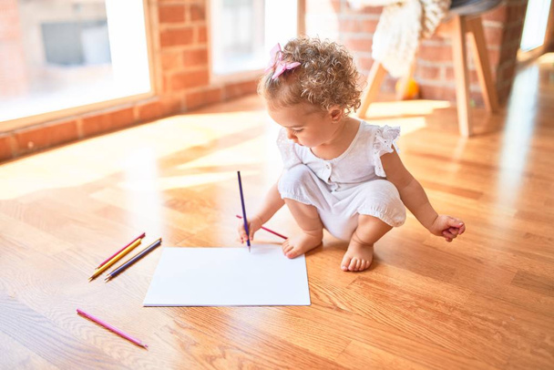 Beautiful caucasian infant playing with toys at colorful playroom. Happy and playful drawing with color pencils at kindergarten. - Foto, Imagen
