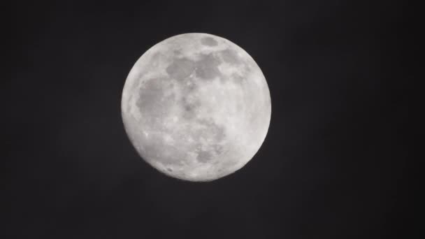 Telihold sötét felhős éjszakán. Felhők haladnak el a hold mellett, valós idejű lövés.. - Felvétel, videó