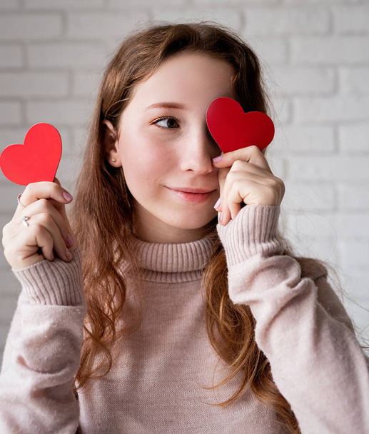 πορτρέτο της νεαρής γυναίκας με κόκκινα σχήματα καρδιά μπροστά από τα μάτια της - Φωτογραφία, εικόνα