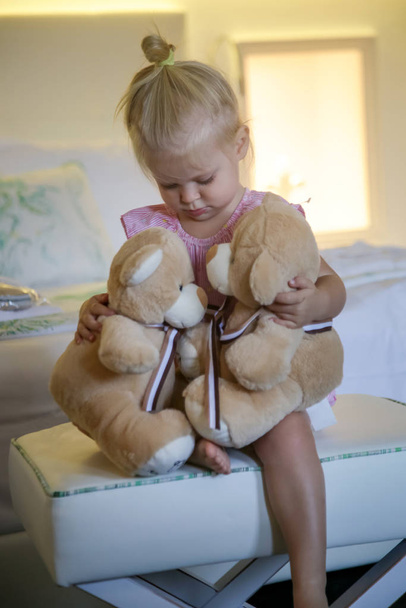 Adorable niña abrazando a dos osos de peluche
 - Foto, imagen